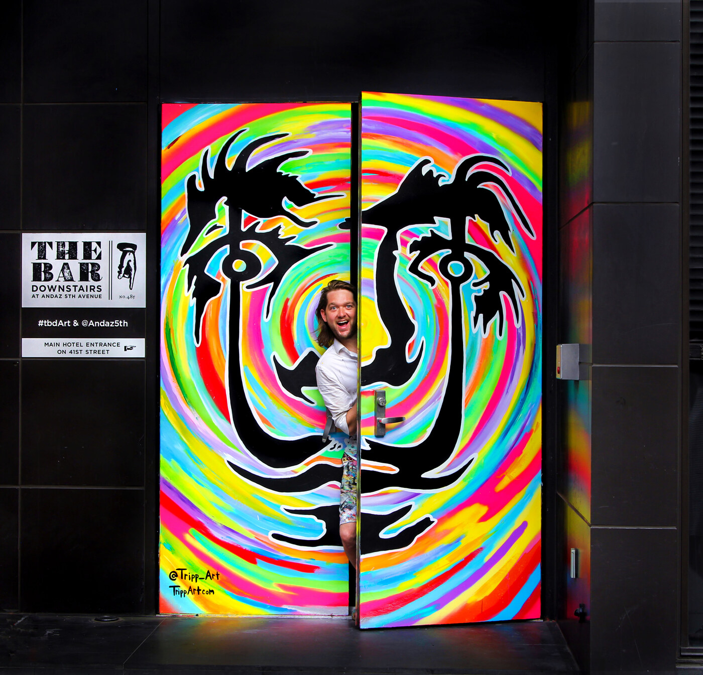 Tripp Art standing inside one of his Dali-style swirl murals at Andaz 5th Avenue in New York.